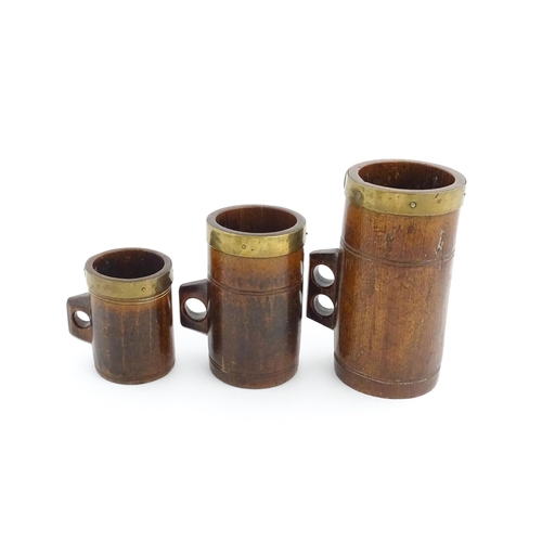 1125 - Treen : Three graduated Victorian and later oak dry measures with brass rims, comprising Quart, Pint... 