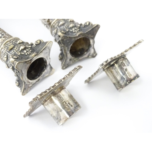 545 - A pair of Edwardian silver candlesticks of column form with urn, acanthus, and acorn and oak leaf ga... 