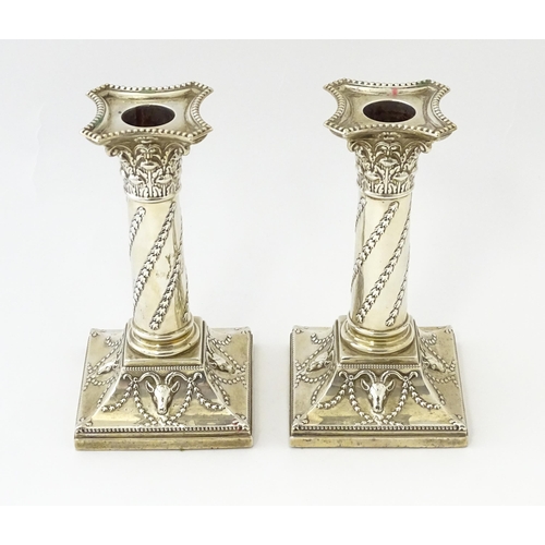 547 - A pair of Edwardian silver candlesticks of column form with swag and rams head detail, hallmarked Lo... 