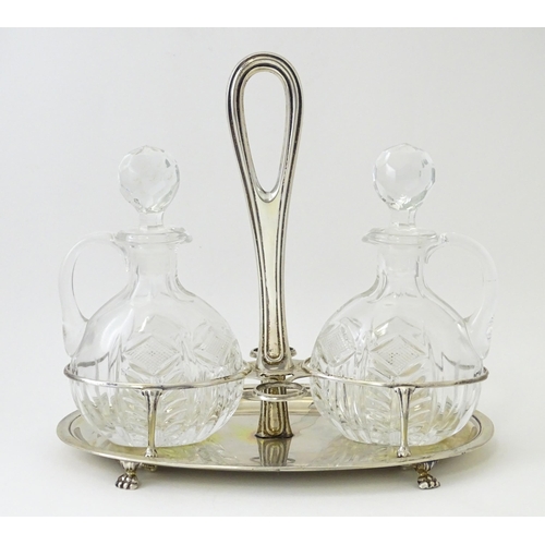 551 - An Italian .800 silver bottle / cruet stand with two glass bottles / jugs of ovoid form. Approx. 7 1... 