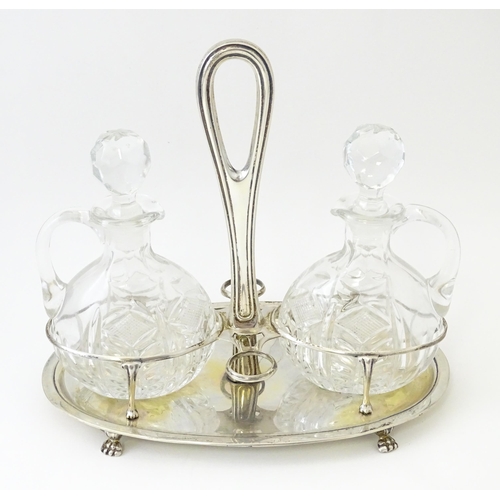 551 - An Italian .800 silver bottle / cruet stand with two glass bottles / jugs of ovoid form. Approx. 7 1... 