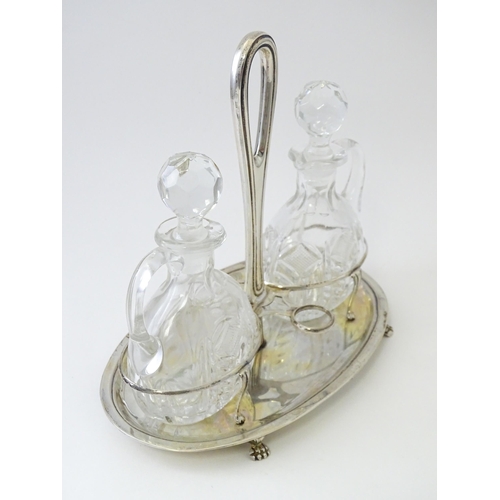 551 - An Italian .800 silver bottle / cruet stand with two glass bottles / jugs of ovoid form. Approx. 7 1... 