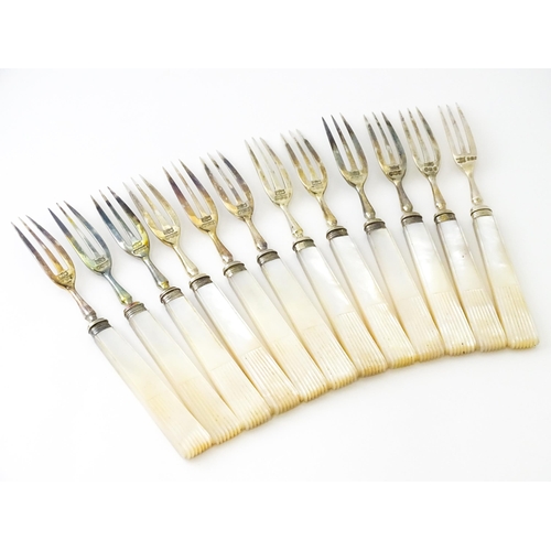 560 - A cased set of twelve silver fruit knives and forks with mother of pearl handles, hallmarked Sheffie... 