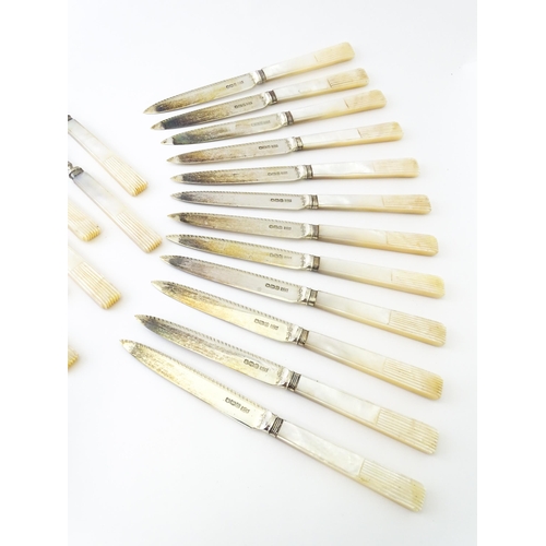 560 - A cased set of twelve silver fruit knives and forks with mother of pearl handles, hallmarked Sheffie... 