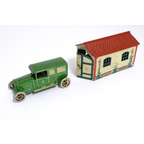 849 - Toys: A Lehmann No. 771 tinplate double door garage with a cream body and green foliage detail, with... 