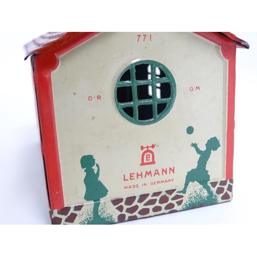 849 - Toys: A Lehmann No. 771 tinplate double door garage with a cream body and green foliage detail, with... 