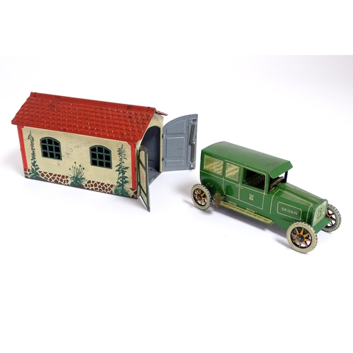 849 - Toys: A Lehmann No. 771 tinplate double door garage with a cream body and green foliage detail, with... 