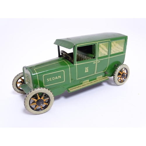 849 - Toys: A Lehmann No. 771 tinplate double door garage with a cream body and green foliage detail, with... 