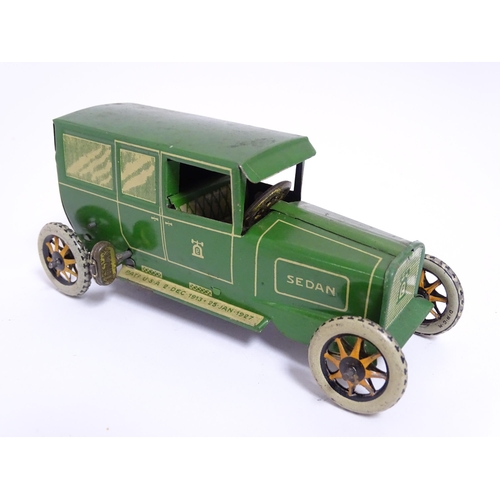 849 - Toys: A Lehmann No. 771 tinplate double door garage with a cream body and green foliage detail, with... 