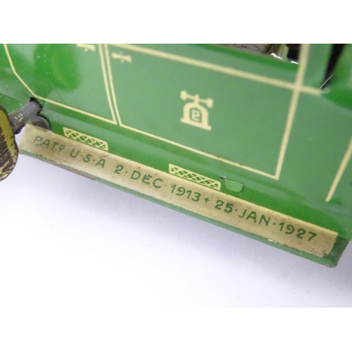 849 - Toys: A Lehmann No. 771 tinplate double door garage with a cream body and green foliage detail, with... 