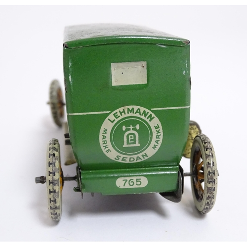 849 - Toys: A Lehmann No. 771 tinplate double door garage with a cream body and green foliage detail, with... 