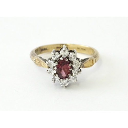 629 - A silver gilt ring set with central garnet bordered by white stones in a  cluster setting. Ring size... 