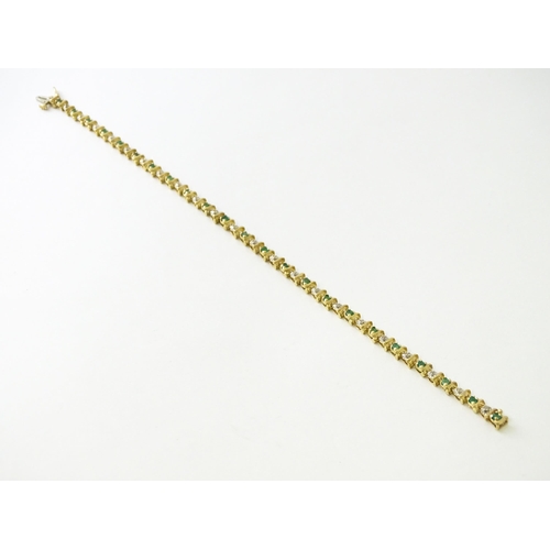 672 - A 9ct gold tennis bracelet set with diamonds and emeralds. Approx. 8