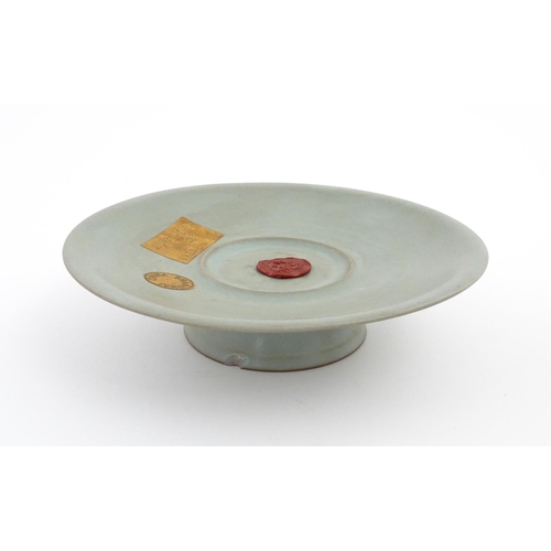 14 - A Chinese celadon footed bowl, bearing wax seal and paper labels. Approx. 7