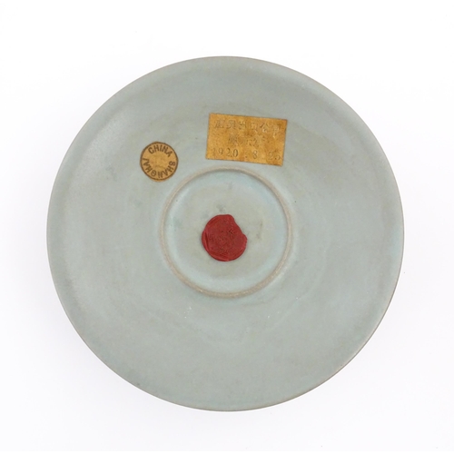 14 - A Chinese celadon footed bowl, bearing wax seal and paper labels. Approx. 7