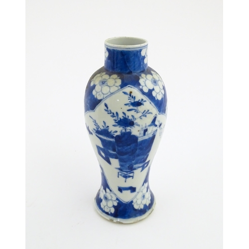 30 - A Chinese blue and white vase decorated with a vase of flowers and prunus blossom. Character marks u... 