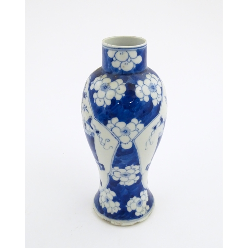 30 - A Chinese blue and white vase decorated with a vase of flowers and prunus blossom. Character marks u... 