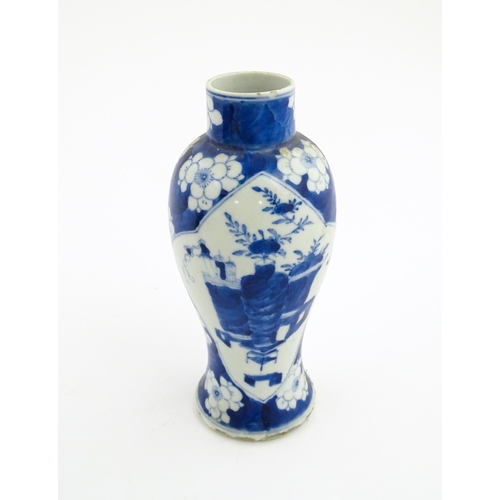 30 - A Chinese blue and white vase decorated with a vase of flowers and prunus blossom. Character marks u... 