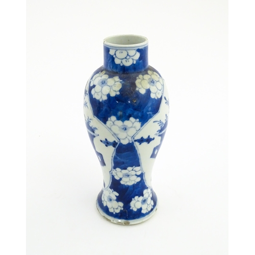 30 - A Chinese blue and white vase decorated with a vase of flowers and prunus blossom. Character marks u... 