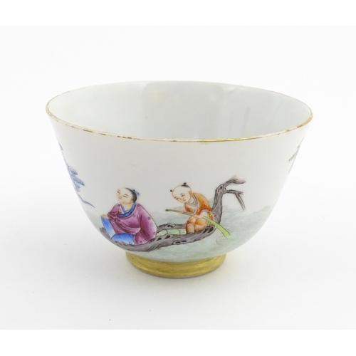 41 - A Chinese famille rose tea bowl decorated with figures in a river landscape. Character marks under. ... 