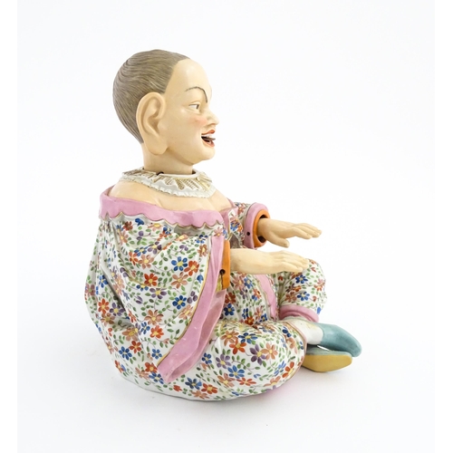 54 - An Ernst Bohne porcelain figure modelled as a seated Chinese / Oriental man with articulated head, t... 