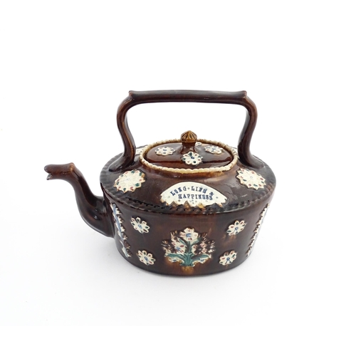 56 - A Victorian Measham bargeware teapot with applied floral and foliate motifs and motto Long Life & Ha... 