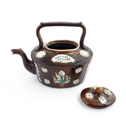 56 - A Victorian Measham bargeware teapot with applied floral and foliate motifs and motto Long Life & Ha... 