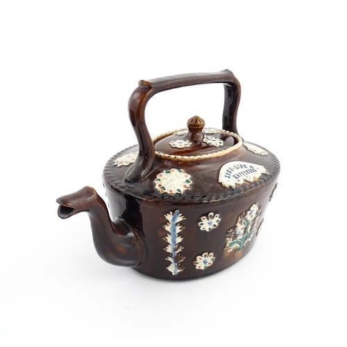 56 - A Victorian Measham bargeware teapot with applied floral and foliate motifs and motto Long Life & Ha... 