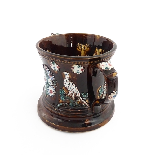 57 - A Victorian Measham bargeware frog loving cup decorated with birds and flowers, the interior with fo... 