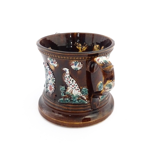 57 - A Victorian Measham bargeware frog loving cup decorated with birds and flowers, the interior with fo... 