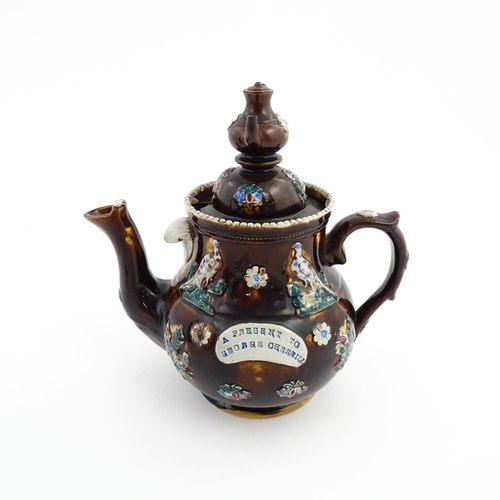 58 - A large Victorian Measham bargeware teapot with a teapot finial to lid, the body decorated with flow... 