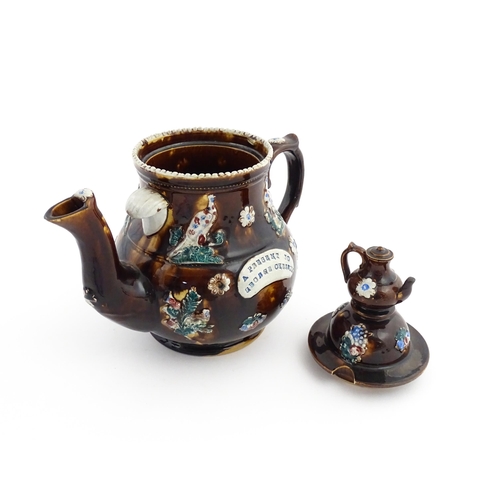 58 - A large Victorian Measham bargeware teapot with a teapot finial to lid, the body decorated with flow... 