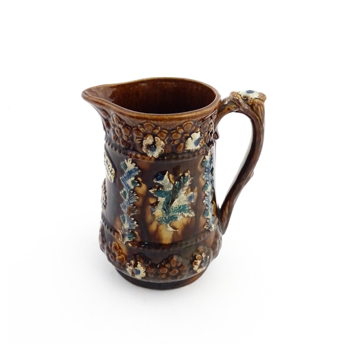 60 - A Victorian Measham bargeware jug with floral and foliate detail, with the motto Serve Me Well I'll ... 