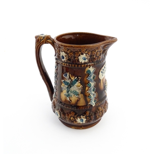 60 - A Victorian Measham bargeware jug with floral and foliate detail, with the motto Serve Me Well I'll ... 