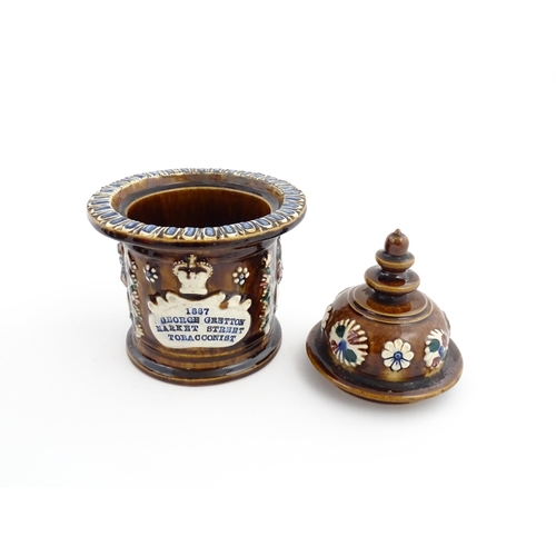 62 - A Victorian Measham bargeware advertising tobacco jar and tamper decorated with flowers and foliage ... 