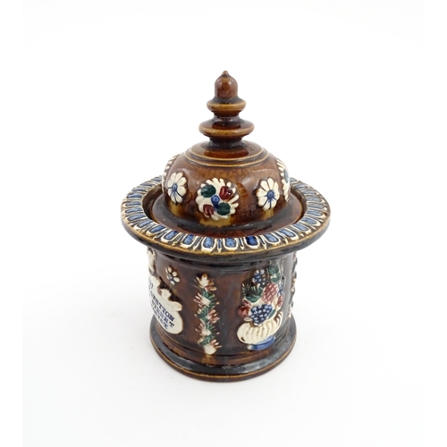 62 - A Victorian Measham bargeware advertising tobacco jar and tamper decorated with flowers and foliage ... 