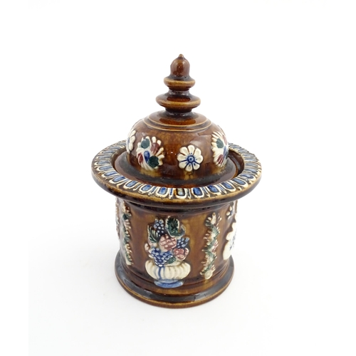 62 - A Victorian Measham bargeware advertising tobacco jar and tamper decorated with flowers and foliage ... 