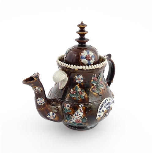 65 - A large Victorian Measham bargeware teapot decorated with applied flowers, thistles, foliage, birds ... 