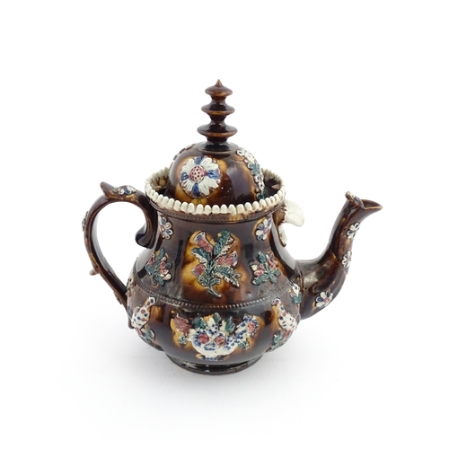 65 - A large Victorian Measham bargeware teapot decorated with applied flowers, thistles, foliage, birds ... 