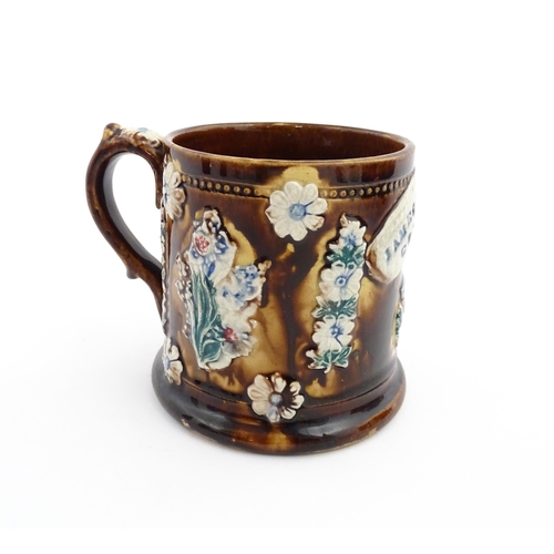 66 - A Victorian Measham bargeware mug decorated with flower, thistles, foliage and a plaque titled James... 