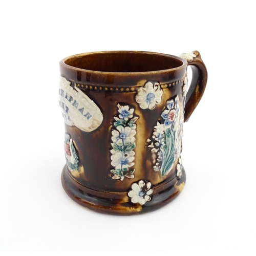 66 - A Victorian Measham bargeware mug decorated with flower, thistles, foliage and a plaque titled James... 