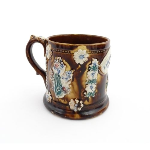 66 - A Victorian Measham bargeware mug decorated with flower, thistles, foliage and a plaque titled James... 