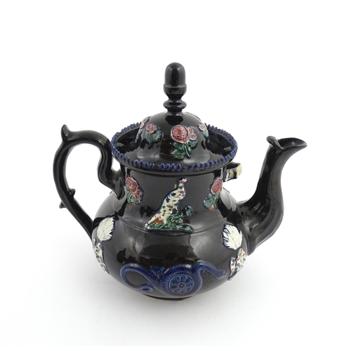 67 - A large Victorian blue Measham bargeware teapot decorated with roses, flower, birds and snakes. Appr... 