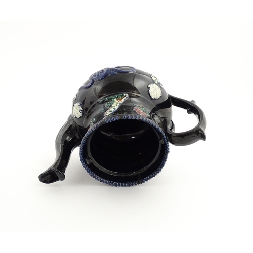 67 - A large Victorian blue Measham bargeware teapot decorated with roses, flower, birds and snakes. Appr... 