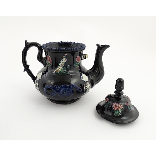 67 - A large Victorian blue Measham bargeware teapot decorated with roses, flower, birds and snakes. Appr... 