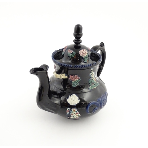 67 - A large Victorian blue Measham bargeware teapot decorated with roses, flower, birds and snakes. Appr... 