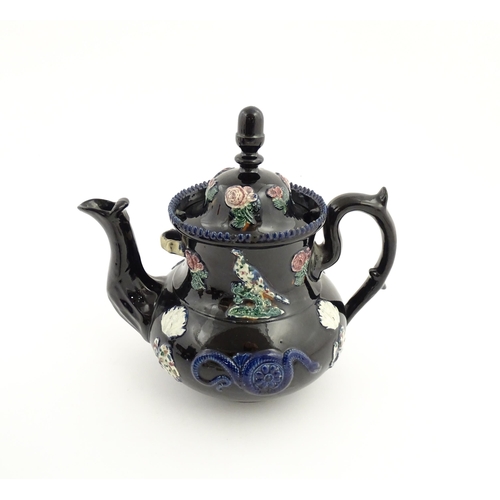 67 - A large Victorian blue Measham bargeware teapot decorated with roses, flower, birds and snakes. Appr... 