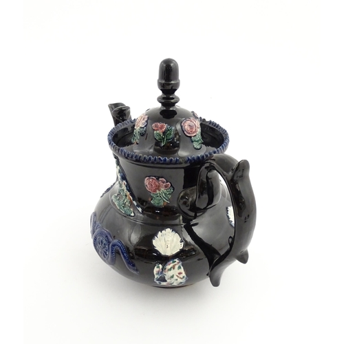 67 - A large Victorian blue Measham bargeware teapot decorated with roses, flower, birds and snakes. Appr... 