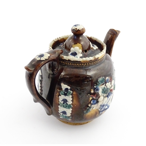 68 - A Victorian Measham bargeware teapot decorated with flowers, a profile portrait and a plaque surmoun... 