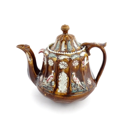 70 - A Victorian Measham bargeware teapot of fluted form decorated with flowers, ferns and birds. Approx.... 